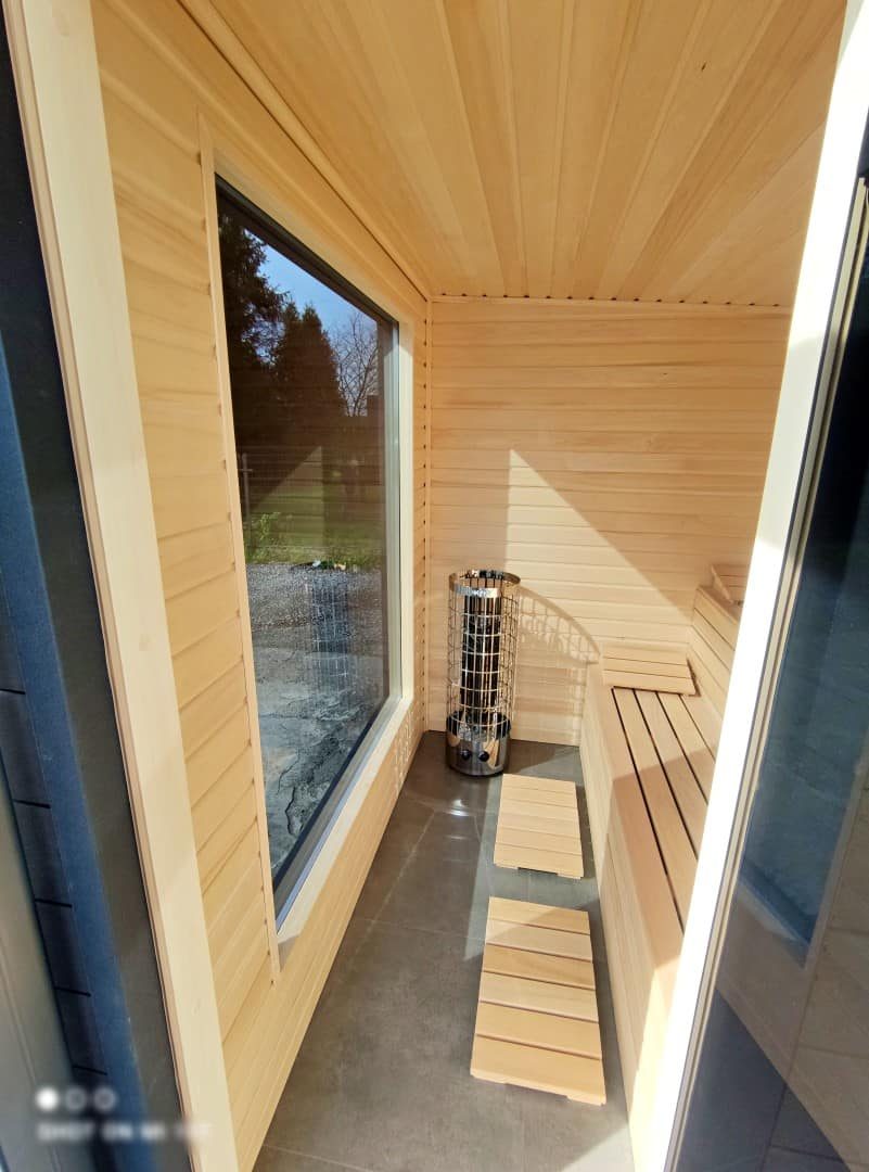 Venkovní finská sauna se zastřešenou terasou a venkovním posezením, foto interiéru
